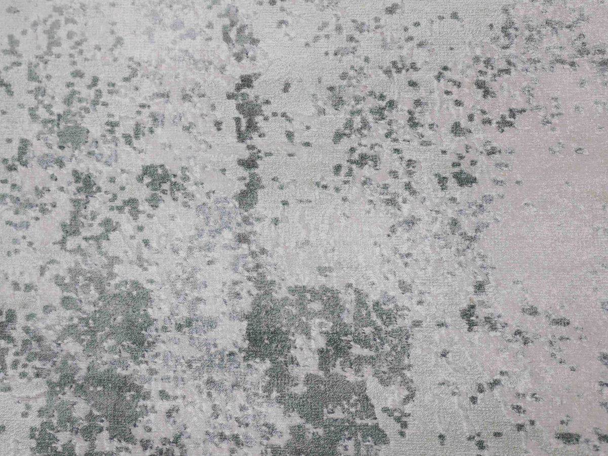 Abstract pattern featuring green and pink speckles on a light gray texture, resembling a weathered or marbled surface.