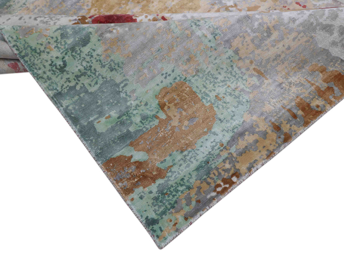 Abstract rug with a textured pattern of green, brown, and gray, creating an earthy, artistic look. The design is vibrant yet tranquil.