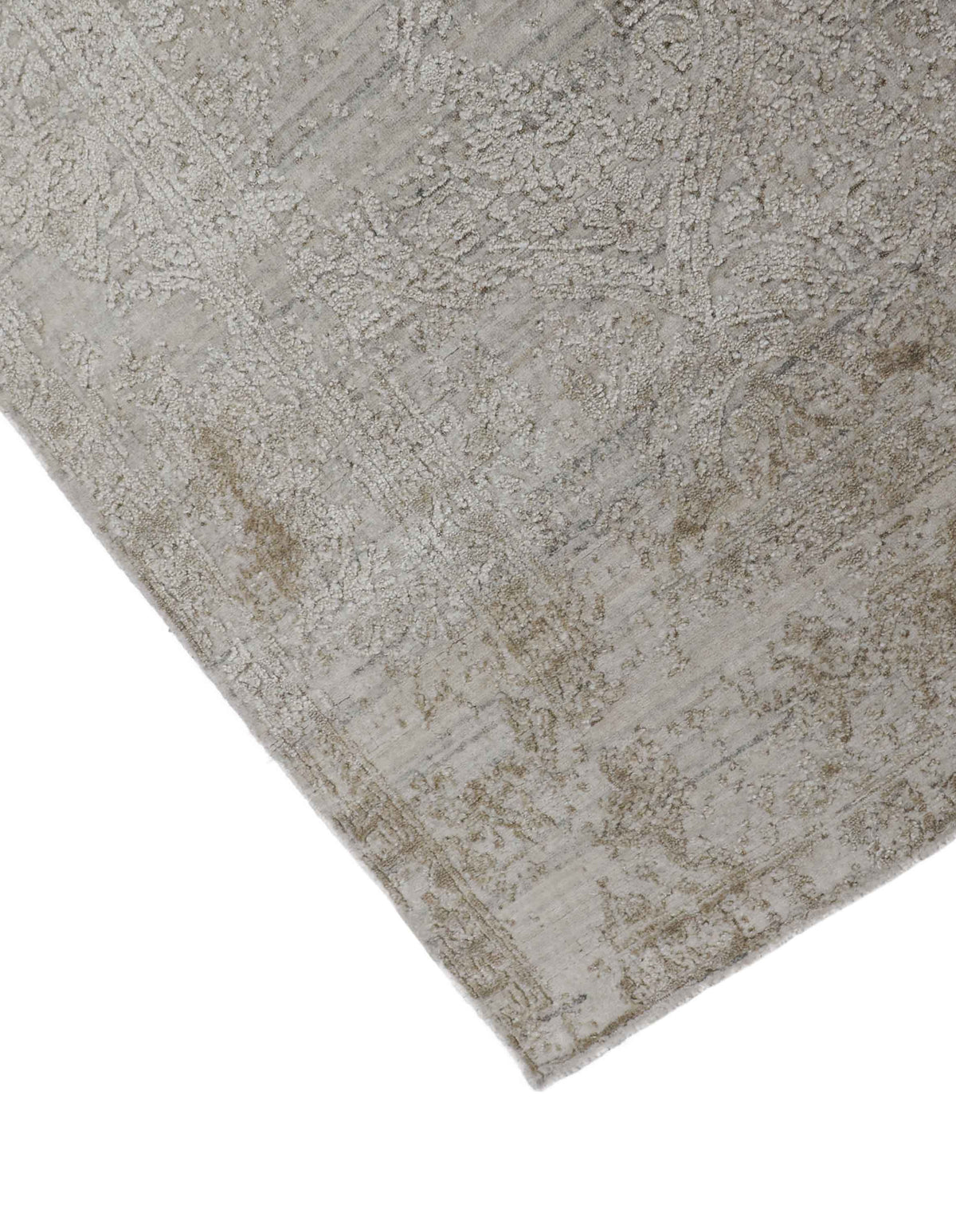 Close-up of a light grey handmade rug with a subtle distressed pattern