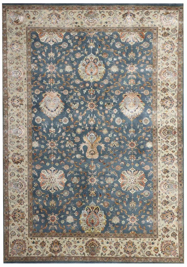 Ornate Persian rug with a blue background, featuring intricate floral patterns and medallions in cream, red, and gold hues. Surrounded by a beige border.