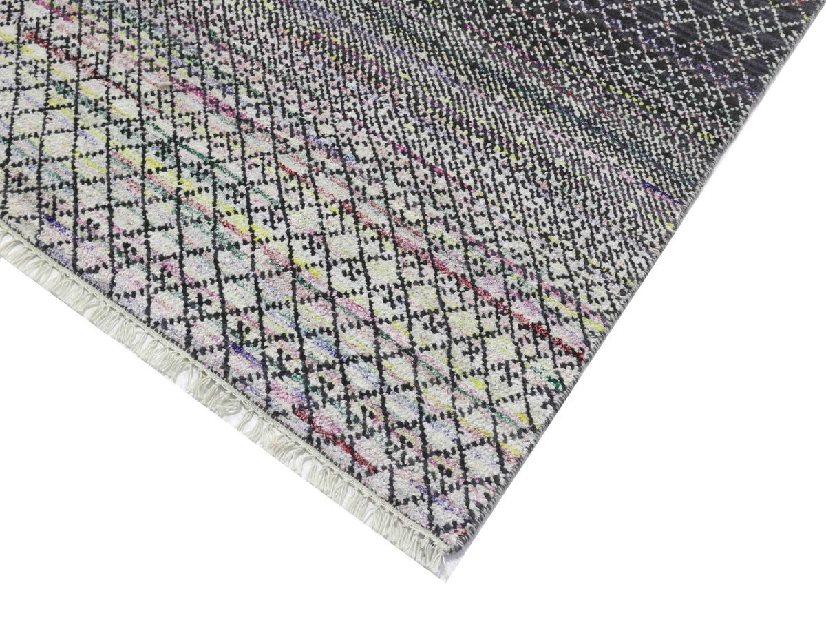 A multicolored woven textile featuring a black grid design with fringed edges. The gradient effect transitions from light at the bottom to dark at the top.